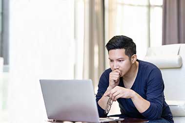 Image of young man using her laptop at home